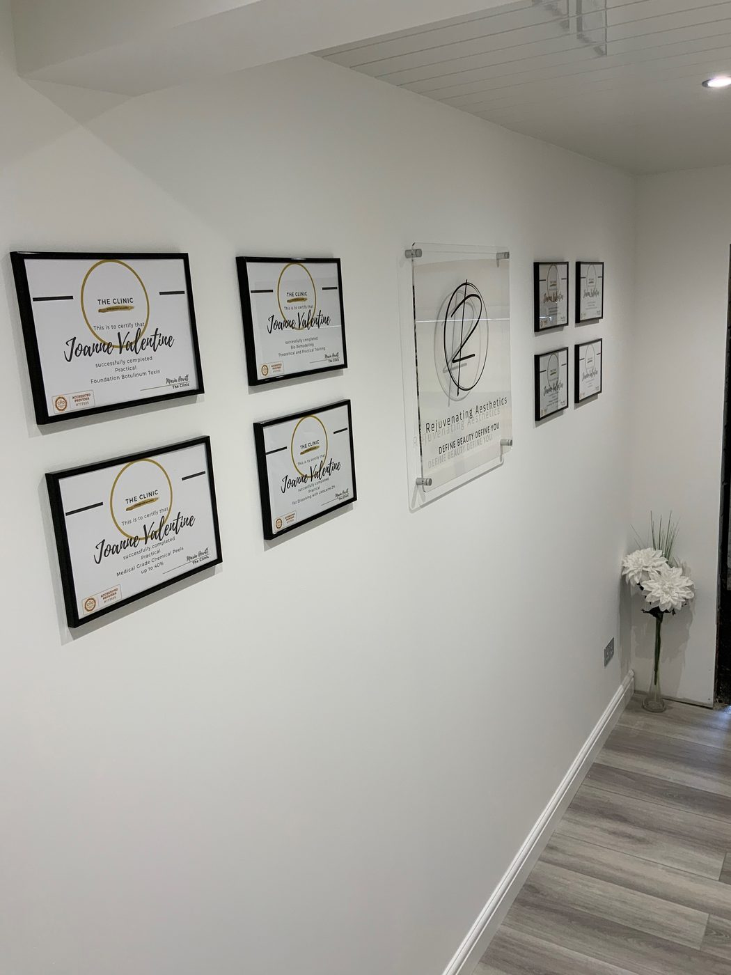 Jo Valentine's training certificates framed along the clinic corridor