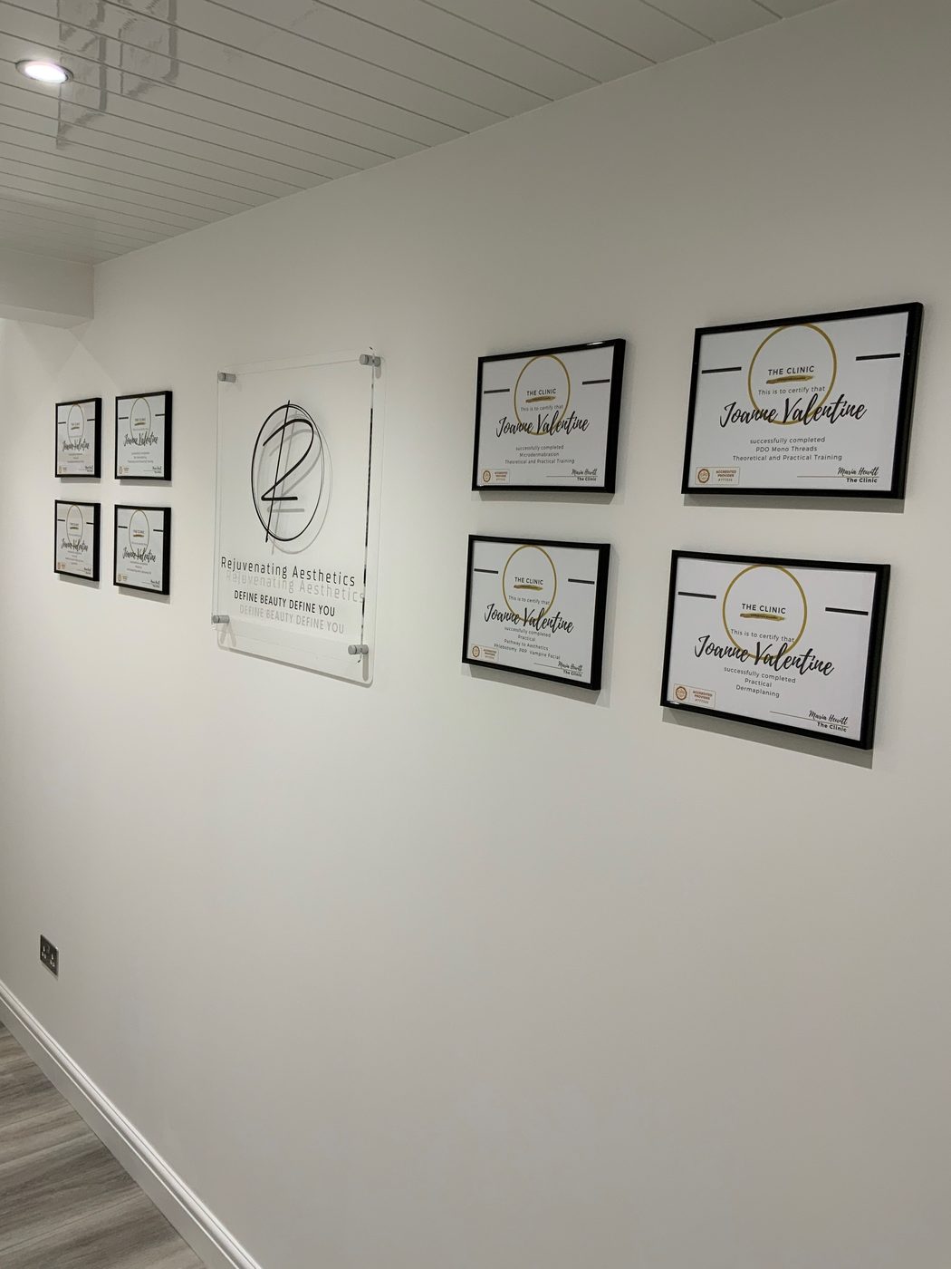 Framed training certificates beside the clinic sign