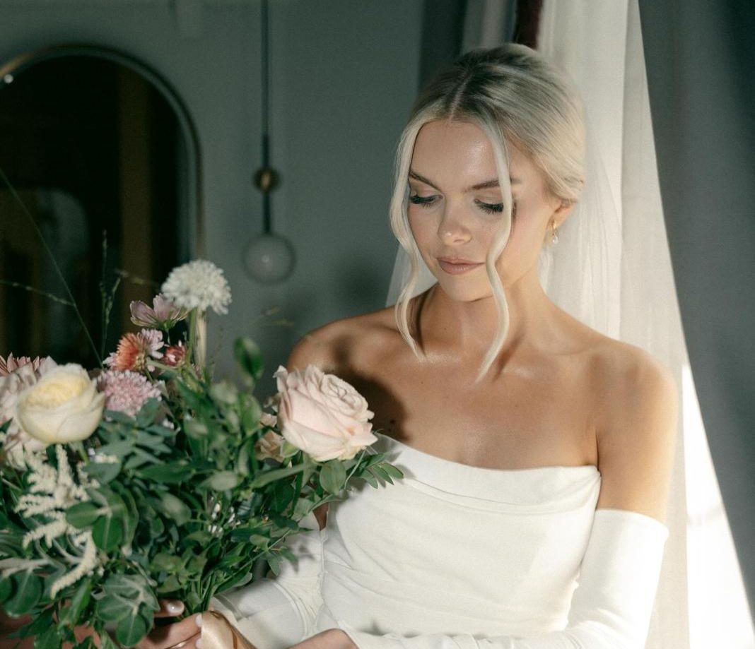 A bride in an off-shoulder dress holding a bouquet