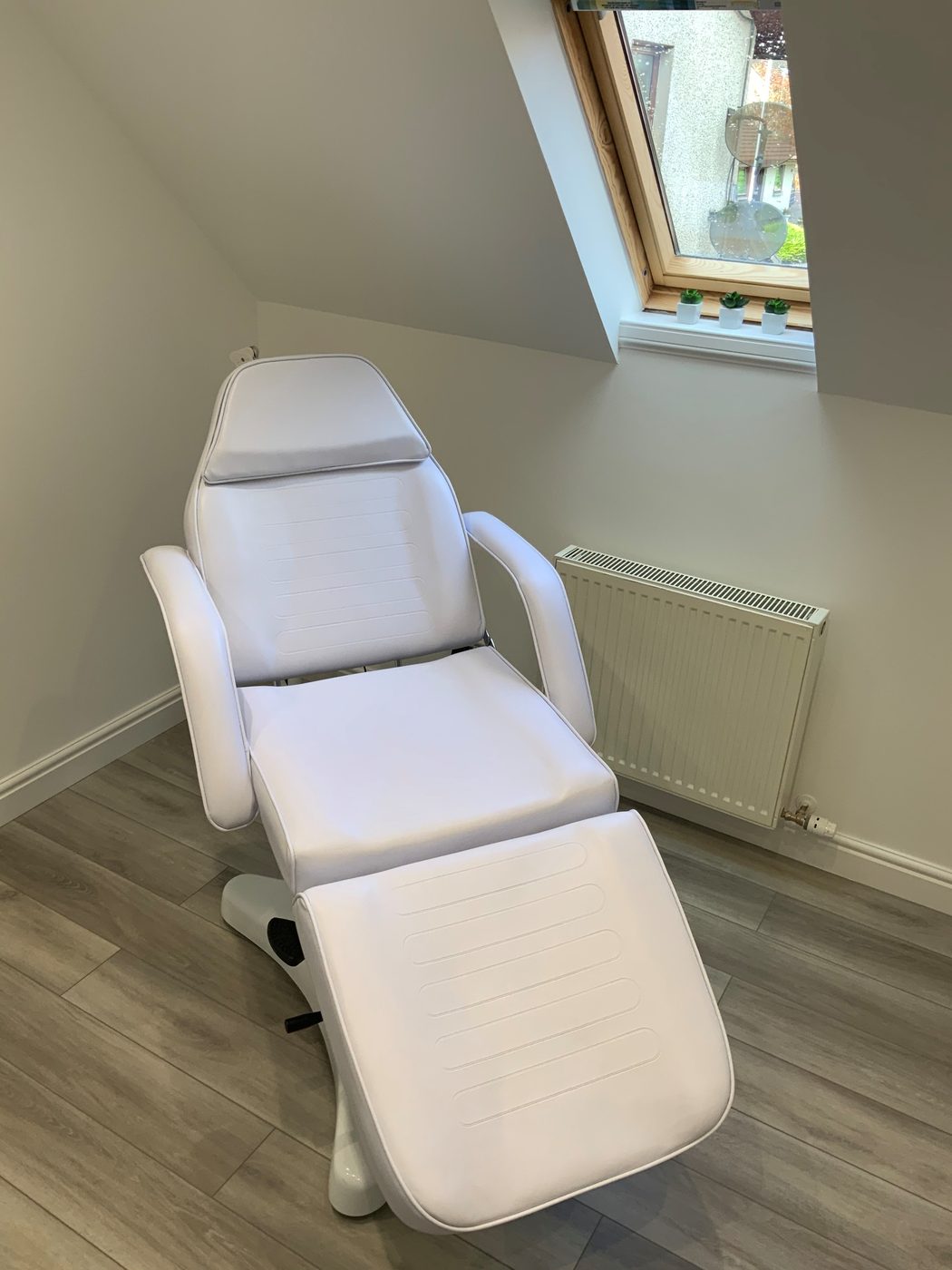 The white treatment chair under the skylight