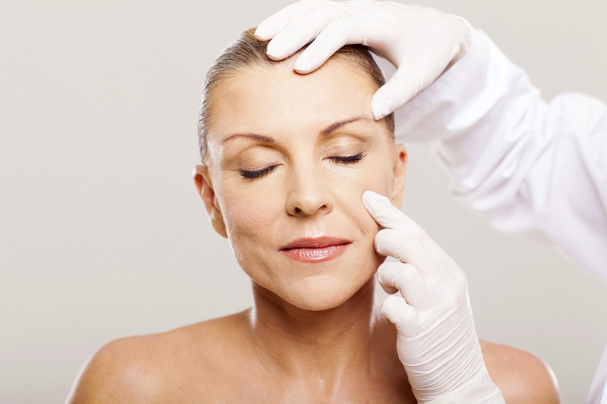 Practitioner assessing a client's skin during a consultation