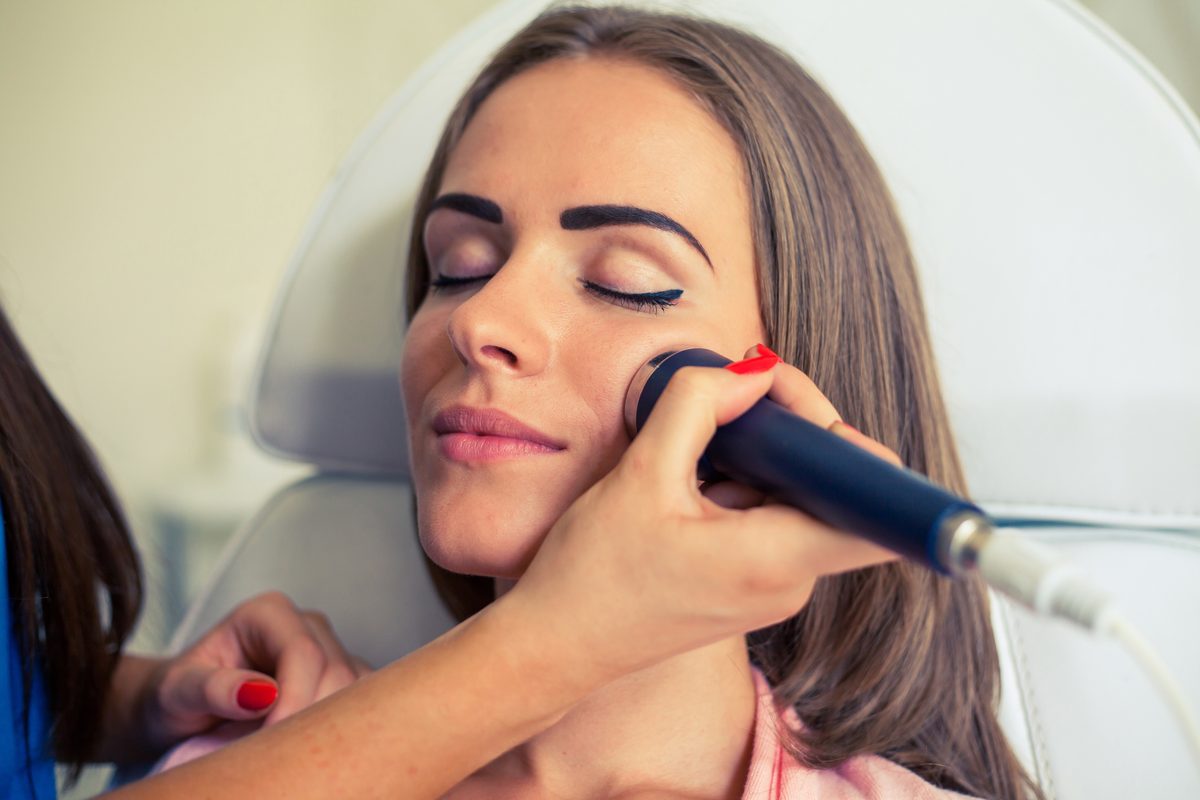 Microdermabrasion device being used on a client's cheek