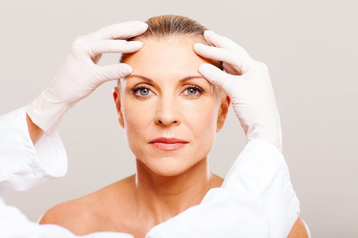 Client with glowing skin having her face assessed